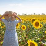 older woman exploring sunflower field