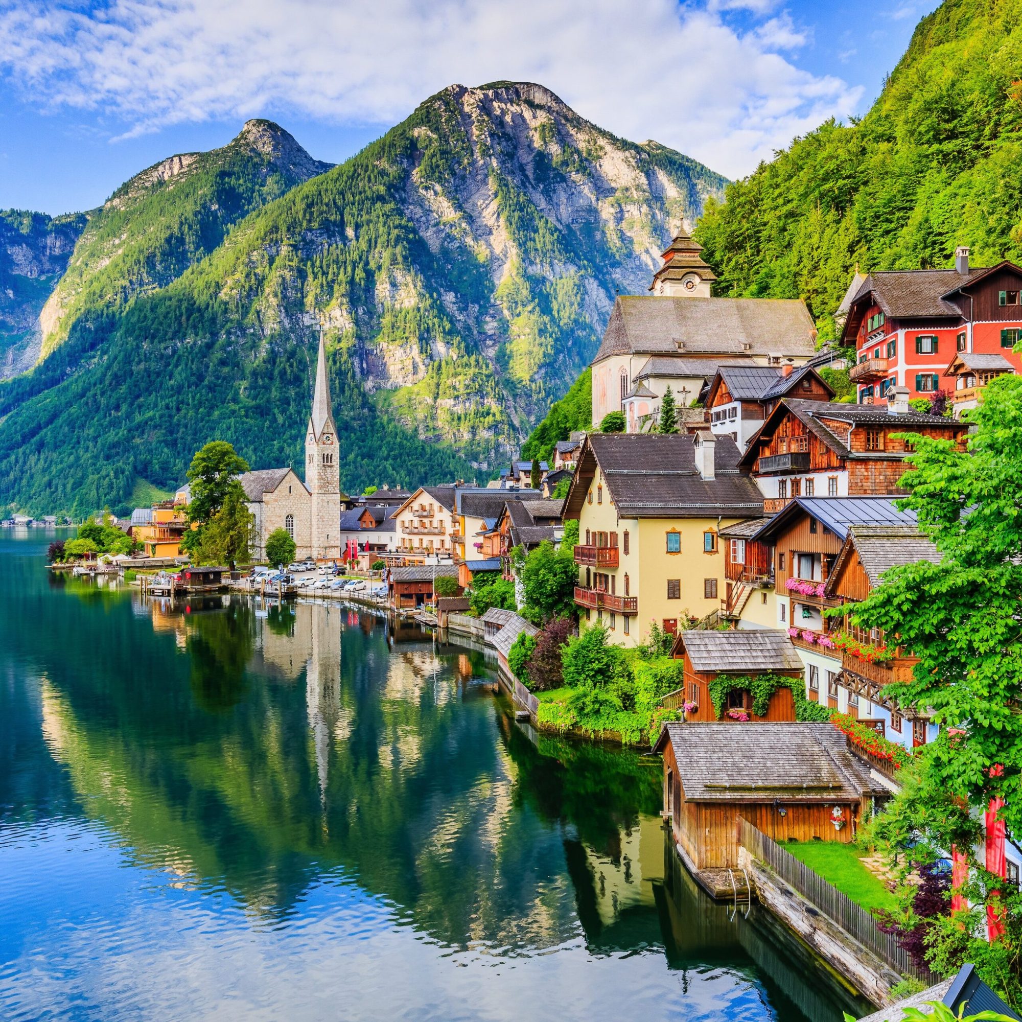 gorgeous alpine scenery: colorful houses on a lake with mountains in background