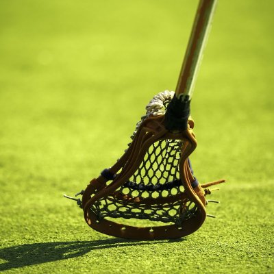 A lacrosse stick hitting the grass.