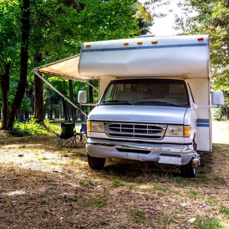 An RV parked at a camping site in a forest.