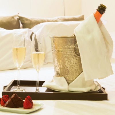 Champagne and chocolate covered strawberries in a hotel room.