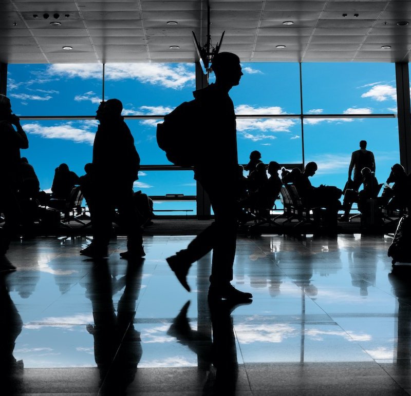 Silhouettes in a busy airport.