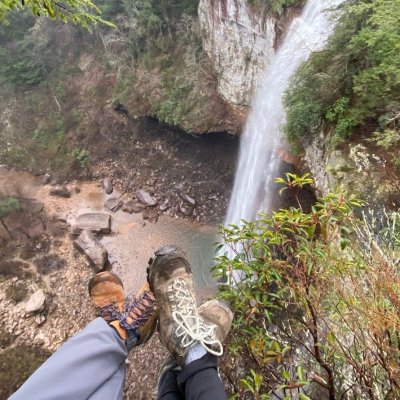 Two hikers facing a waterfall.