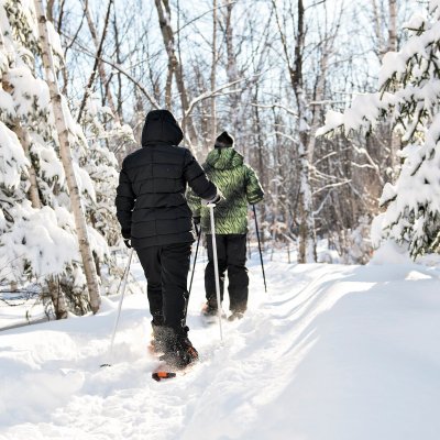 Two people snowshoeing during the winter.
