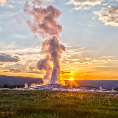 Old Faithful Geyser Eruption in Yellowstone National Park at Sunset