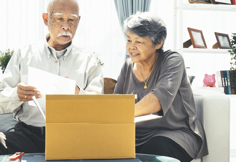 senior man and woman opening gift box at home