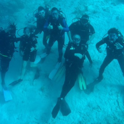 Underwater scuba divers pose for underwater group picture.