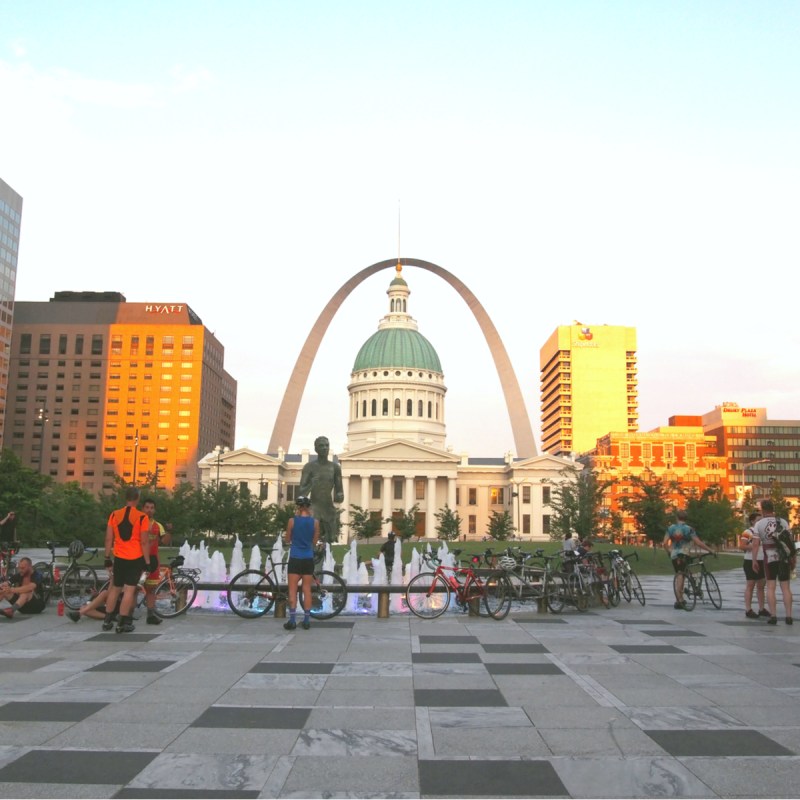 Bicyclists near the Gateway Arch and the Mississippi River.