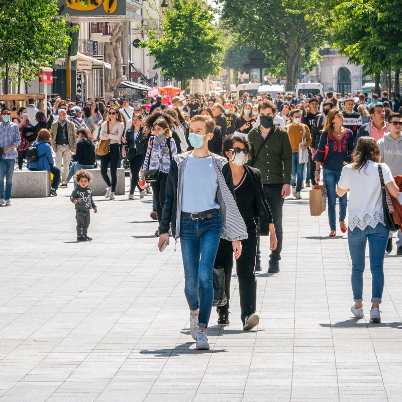 People walking down the street wearing face masks in Lyon France.