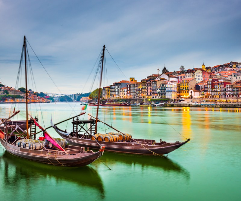 Porto, Portugal old town cityscape on the Douro River with traditional Rabelo boats