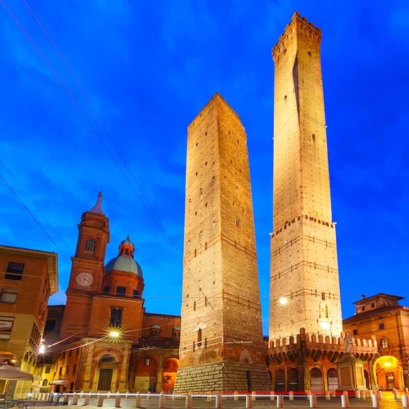 Two Towers, Asinelli and Garisenda, both of them leaning, symbol of Bologna, statue of San Petronius and Church of Saints Bartholomew and Gaetano in the morning, Bologna, Emilia-Romagna, Italy