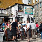 The Sloop Inn traditional 14th century pub busy with holidaymakers sitting outside.