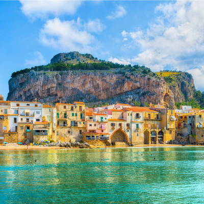The town of Cefalù, Sicily, Italy, with La Rocca standing behind.