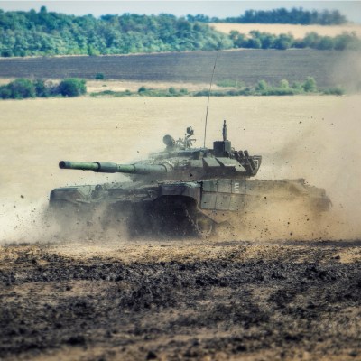 Tank driving through dirt.