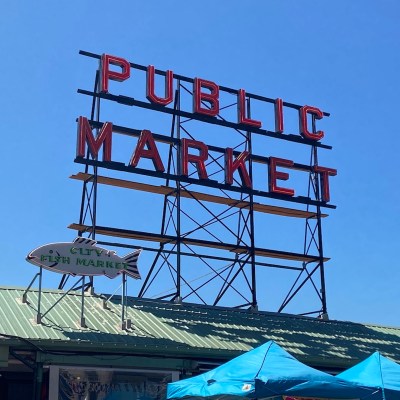 Public Market neon sign with smaller fish shaped sign underneath.