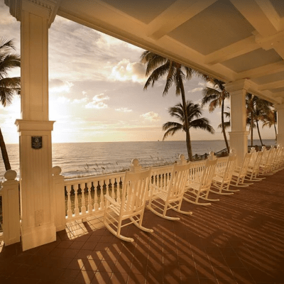 row of white rocking chairs looking out over the Atlantic ocean at a condominium in Fort Lauderdale