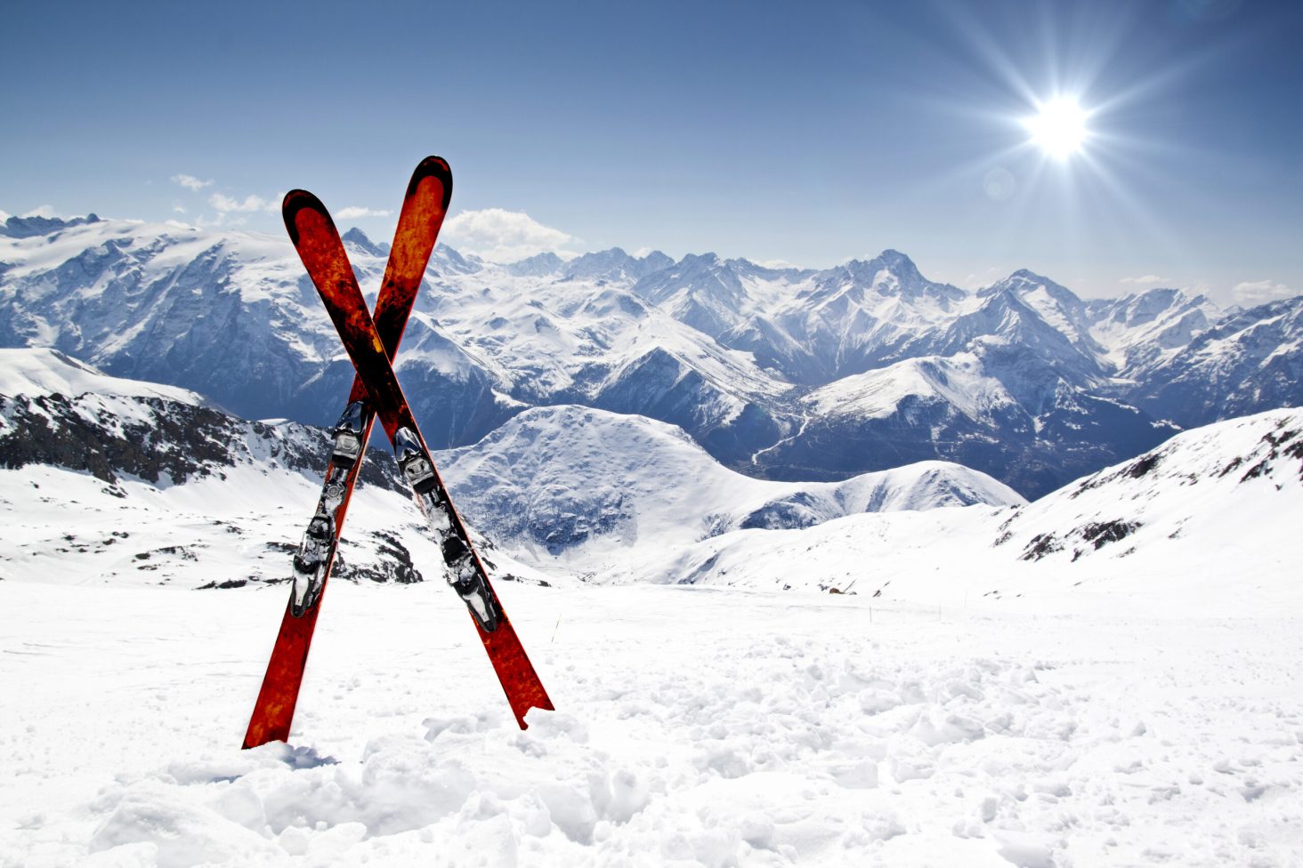 Pair of cross skis in snow in front of mountains