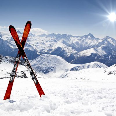 Pair of cross skis in snow in front of mountains