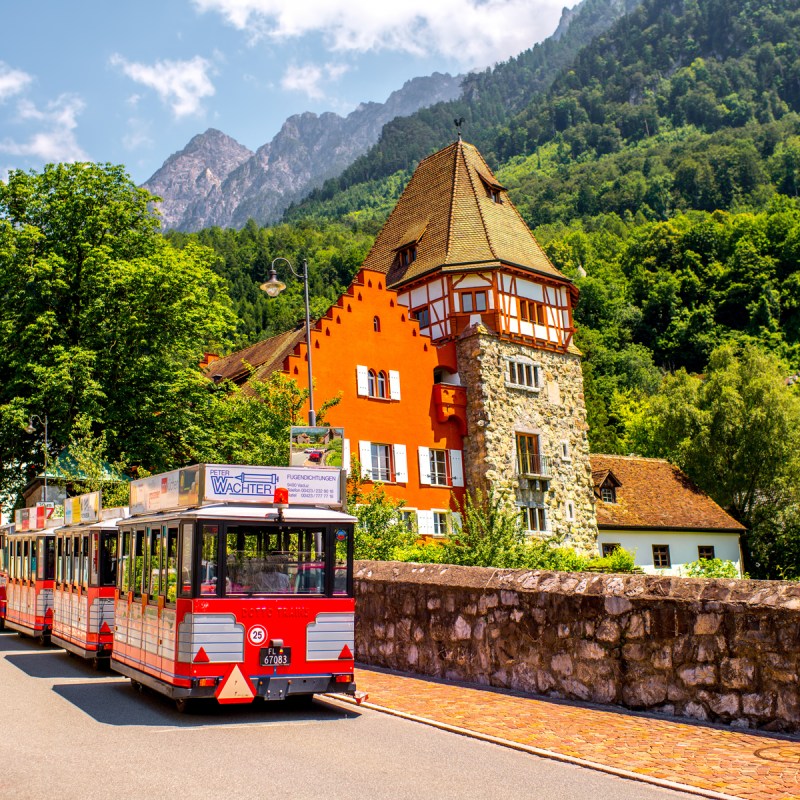 People on the tourist train visit famous red house with wineyard in Vaduz city.