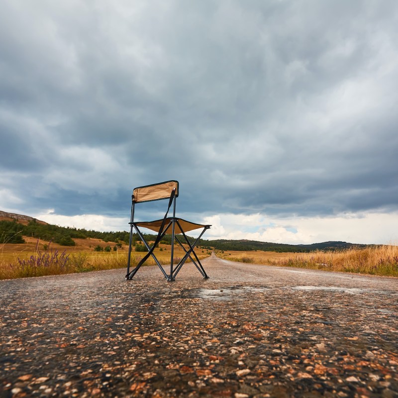 Empty chair in road on rainy day