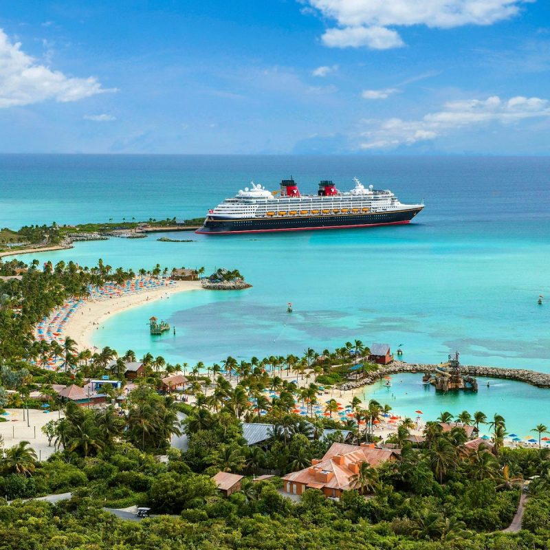 Disney Cruise Line off the coast of tropical island.