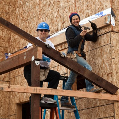 Two women build home wall for Habitat For Humanity.