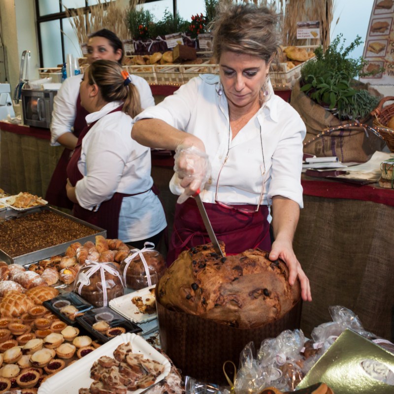 A woman cuts panettone, a traditional Italian Christmas cake, in Milan