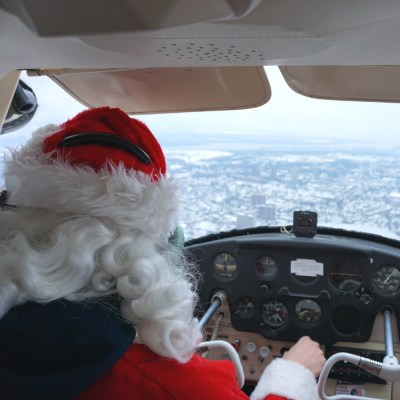 Santa in the cockpit of the vintage Cessna airplane.