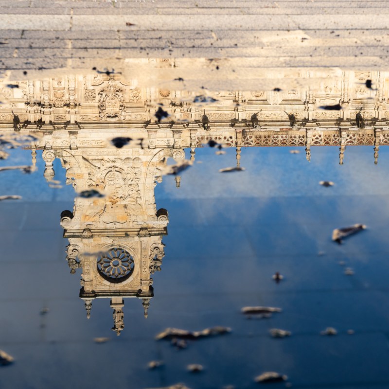 San Marcos church and square reflected on a puddle of water in a sunny day in Leon, Spain.