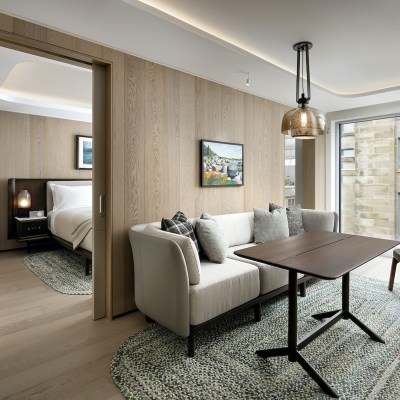 Living room section of the junior suit with a couch and coffee table with bedroom visible at the back