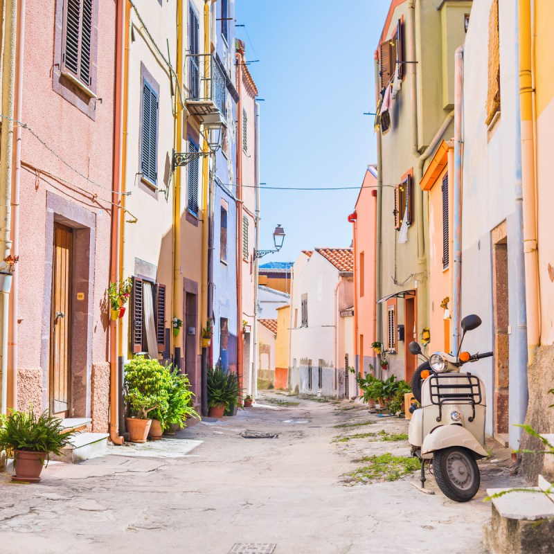 Old-fashioned scooter in a picturesque street of tiny Bosa town, Sardinia island