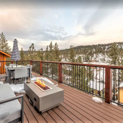 fire pit on porch of Big Bear vacation home overlooking snowy woods in Big Bear