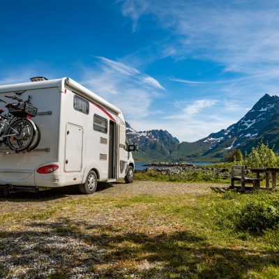 RV rental parked in camping spot near mountains