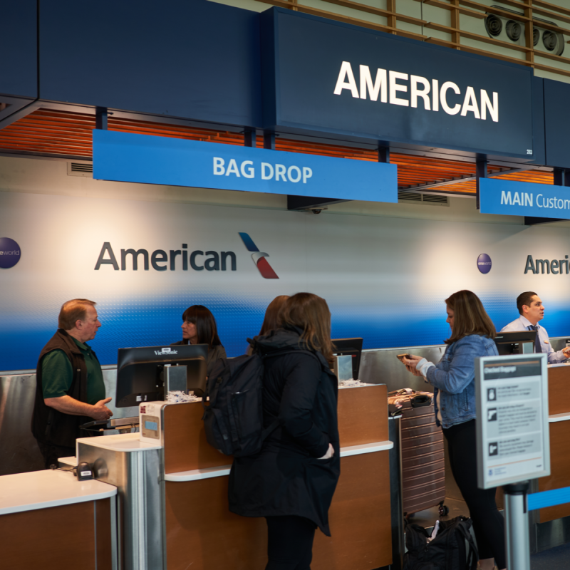 Passengers check their baggages at the American Airlines check-in desk in Portland International Airport.