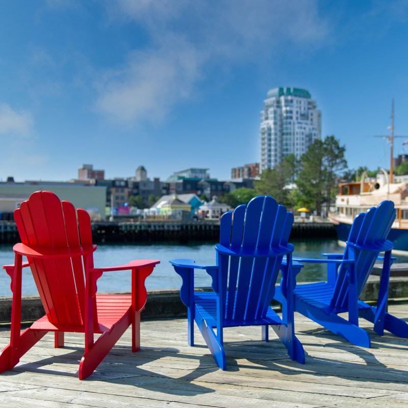 Three Adirondack chairs along the waterfront in Halifax, Nova Scotia, Canada.