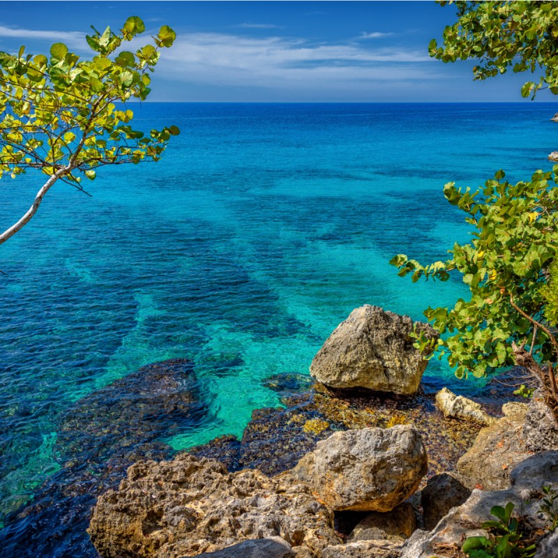 Beautiful turquoise and blue water near rocks and cliffs in Negril, Jamaica.