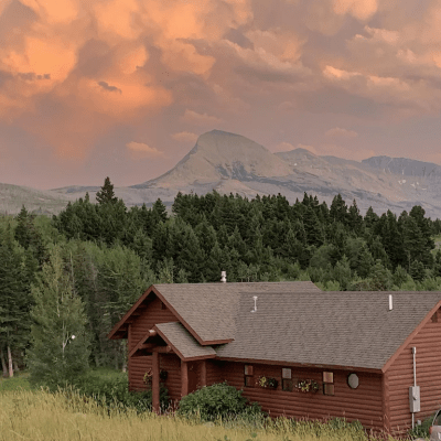 vacation rental in foreground, evergreen trees, mountains in background