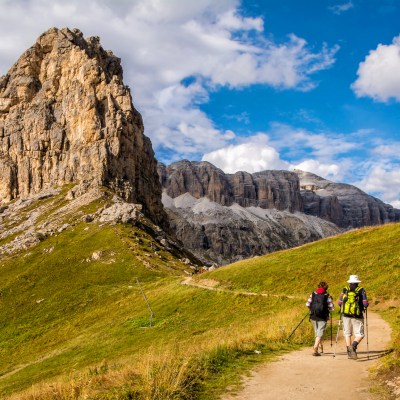 Active senior caucasian couple hiking in mountains with backpacks, enjoying their adventure.