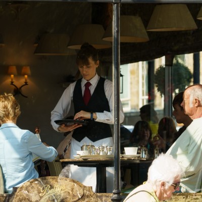 Waitress serving a couple at a table in Bettys Café Tea Rooms.