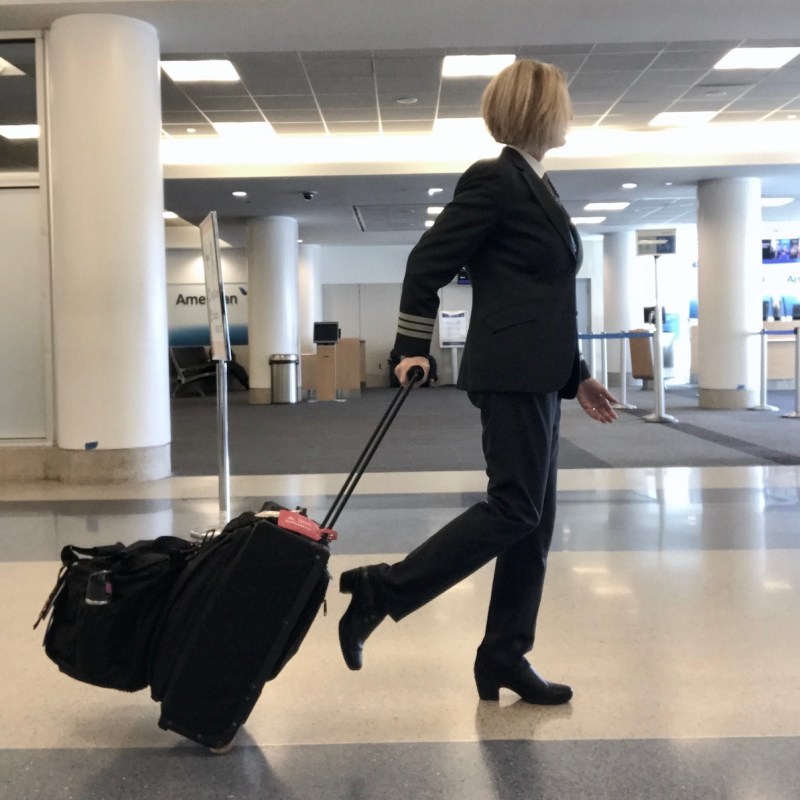 Strolling in the airport with a carry-on and personal bag