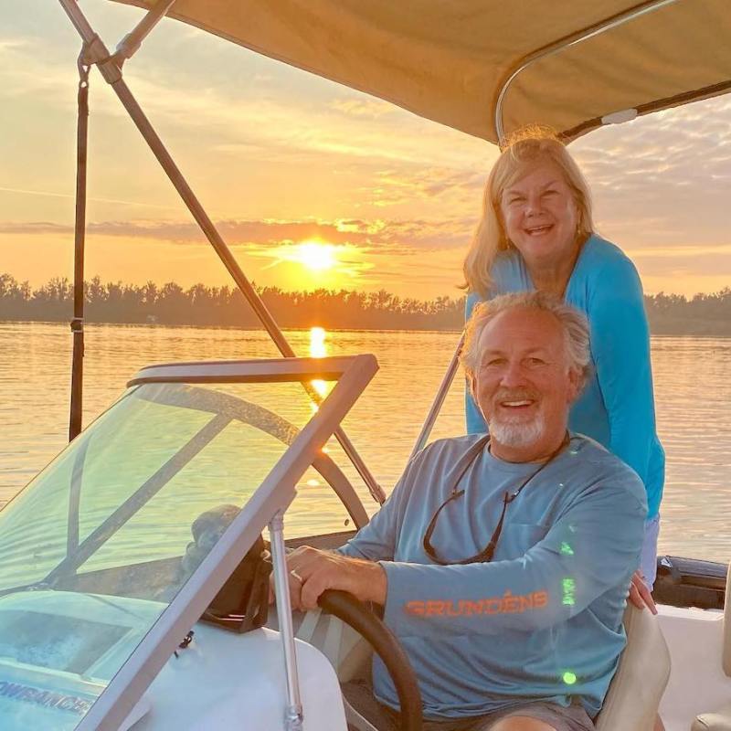 mature couple on boat at sunset