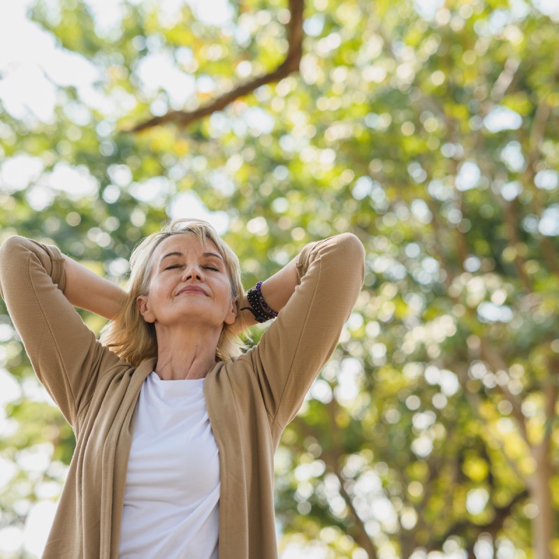 Woman breaths in fresh air at the park