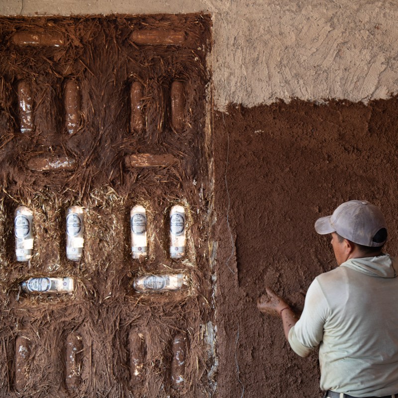 A construction worker at the Agave House, using bottles of tequila