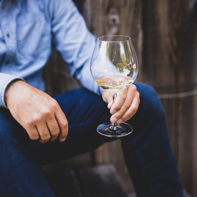man holding glass of white wine