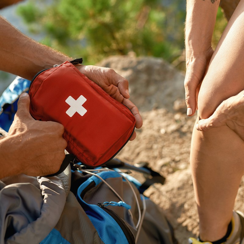Young caucasian man holding first aid kit for healing injured woman