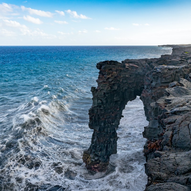 Wave approaching Hōlei Sea Arch in Hawai'i Volcanoes National Park.