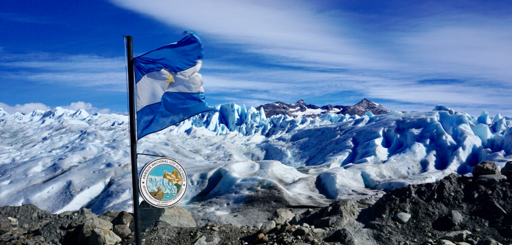 A flag waves in front of Perito Moreno Glacier in Argentina.