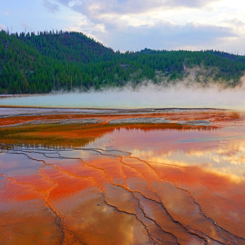 Fiery orange sunset over the Grand Prismatic pool in Yellowstone National Park