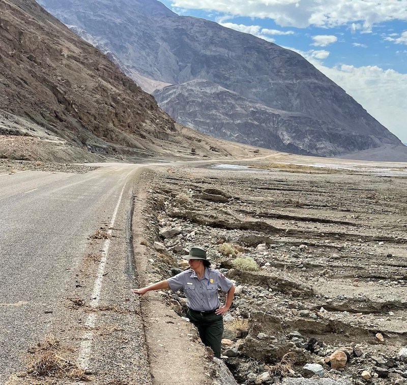 National Park Service spokesperson stands next to eroded roadside