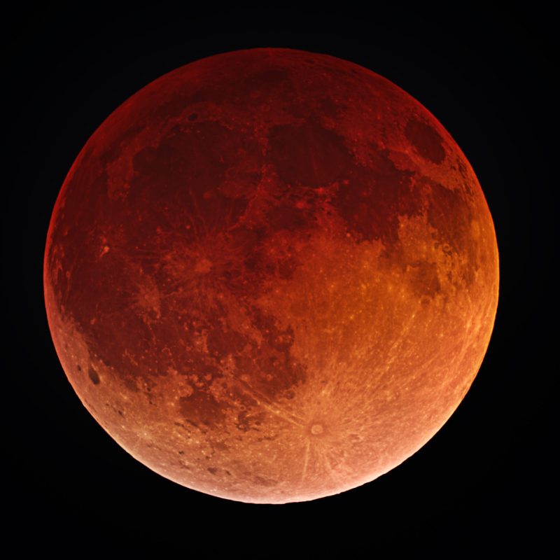 full moon tinted red against dark sky